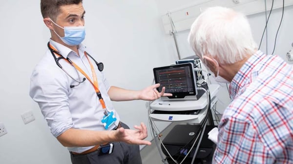 Doctor performs examination and speaks with elderly patient